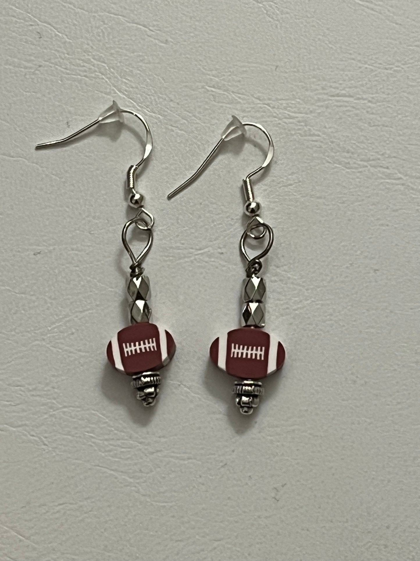 Game Day pair of earrings with football-shaped beads styled by Eliza Joe Jewelry