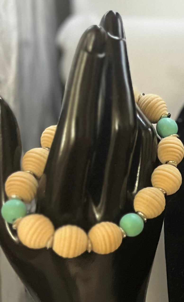 Close-up of matching aqua and wood bracelet with beachy tones