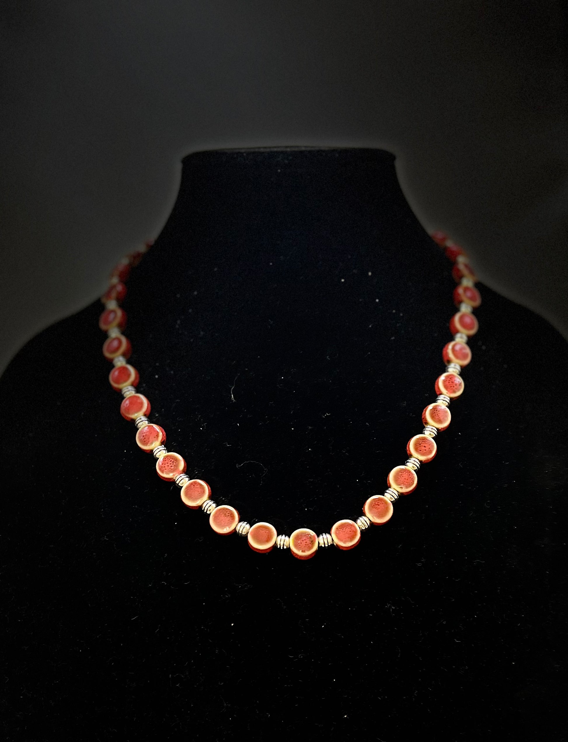 Close‑up of red ceramic jewelry set with vibrant shine